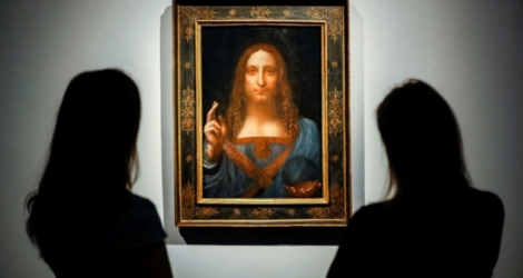 Des employés de Christie's regardent le 22 octobre 2017 à Londres le tableau du peintre italien Léonard de Vinci adjugé 450,3 millions de dollars le 15 novembre 2017 à New York 
