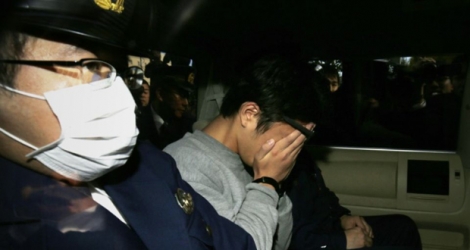 Takahiro Shiraishi, soupçonné d'avoir tué et dépecé neuf personnes rencontrées sur Twitter, se cache le visage entre les mains dans une voiture de police