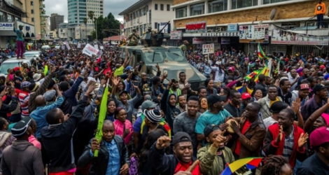 Des habitants de Harare applaudissent l'armée, lors d'une manifestation pour réclamer la démission du président Robert Mugabe, le 18 novembre 2017 au Zimbabwe 