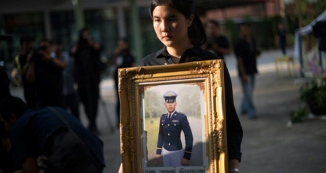 Supicha Tanyakan porte un portrait de son frère, le soldat thaïlandais Pakapong Tanyakan, le 10 décembre 2017 à Chon Buri en Thaïlande.
