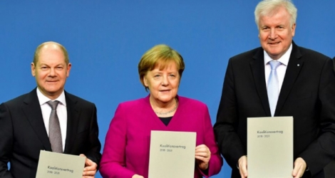 La Chancelière allemande Angela Merkel, le ministre allemand des Finances Olaf Scholz (g) et le ministre allemand de l'Intérieur Horst Seehofer, après la signature d'un accord de coalition avec les sociaux-démocrates, le 12 mars 2018 à Berlin