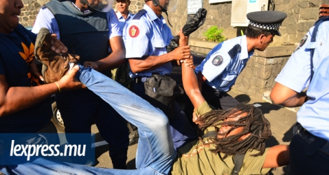 Des policiers traînant un rastafari après un rassemblement le 6 mai 2016 à Port-Louis. © Beekash Roopun