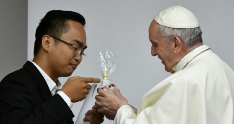 Le pape François reçoit un cadeau lors d'une rencontre avec des jeunes avant l'ouverture d'un synode à Rome, le 19 mars 2018.