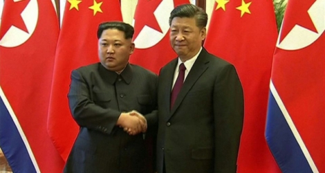 Le président chinois Xi Jinping et le dirigeant nord-coréen Kim Jong Un (g), sur des images diffusées par la télévision chinoise, le 28 mars 2018 lors de leur rencontre à Pékin 