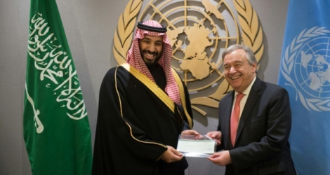 Le prince héritier saoudien Mohammed ben Salmane (g) remet au secrétaire général de l'ONU, Antonio Guterres, un chèque de 930 millions de dollars pour financer le programme d'aide de l'ONU au Yémen, le 27 mars 2018 à New York.