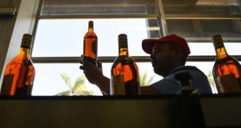 Des bouteilles de rhum sont vérifiées lors d'un contrôle qualité à la distillerie du Havana Club à San José, près de La Havane, le 15 mars 2018 