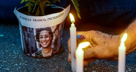 Un homme allume des bougies lors d'un rassemblement, le 15 mars 2018 à Sao Paulo, en hommage à la conseillière municipale Marielle Franco assassinée.