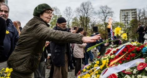 Une femme dépose des jonquilles devant le monument déposent des fleurs devant le monument aux Héros du Ghetto, le 19 avril 2016 à Varsovie, en Pologne.