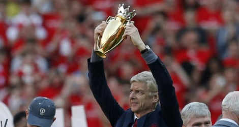 Arsène Wenger brandit la coupe dorée qui lui est décernée pour l'ensemble de son oeuvre avec Arsenal, le 6 mai 2018 à l'Emirates Stadium.