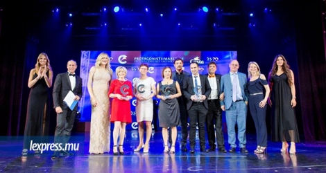 La directrice d’Atom Travel, Caroline Chen (au centre en robe noire) avec son trophée. 