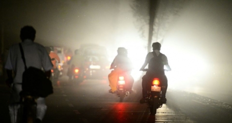 Des usagers roulent en scooters lors d'une tempête à Allahabad, en Uttar Pradeshn dans le nord de l'Inde, le 13 mai 2018.