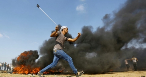 Un manifestant palestinien lance un projectile durant les heurts à la frontière entre la bande de Gaza et Israël, le 15 mai 2018 
