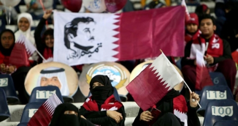 Des spectateurs d'un match de football au Qatar brandissent le drapeau national avec l'effigie de l'émir cheikh Tamim ben Hamad Al-Thani, prise le 23 décembre 2017 au Koweït