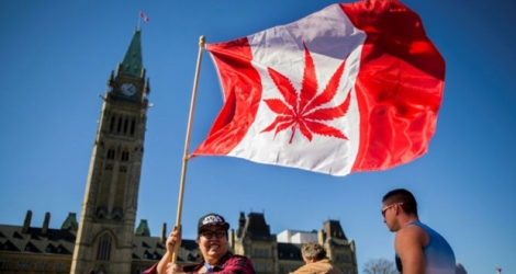 Une feuille de cannabis sur un drapeau canadien lors d'un rassemblement devant le Parlement, le 20 avril 2018 à Ottawa.