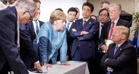 Photo prise par un photographe officiel pour le gouvernement allemand, le 9 juin 2018 à la Malbaie, au Québec, du président américain Donald Trump, assis, faisant face à la chancelière allemande Angela Merkel et aux autres participants du G7.