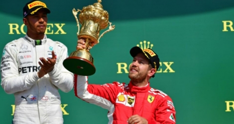 Sur le podium, le pilote britannique Lewis Hamilton applaudit son rival Sebastian Vettel, vainqueur du GP de Grande-Bretagne à Silverstone, le 8 juillet 2018.