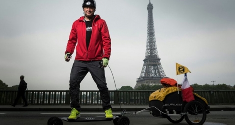 Le Français Fabrice Gropaiz à Paris, devant la tour Eiffel, le 15 mai 2018, avant de se lancer dans son tour du monde en son skate électrique.