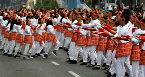 Des danseurs indonésiens, habillés en blanc et rouge aux couleurs du drapeau national, interprètent la danse folklorique 
