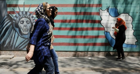 Des Iraniennes passent devant la façade de l'ancienne ambassade des Etats-Unis à Téhéran le 7 août 2018. 
