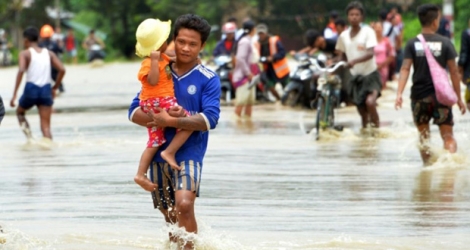 Des habitant se déplacent sur une rue inondée dans la région de Bago, en Birmanie, le 29 août 2018.
