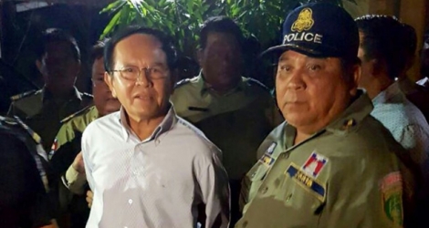 Le chef de l'opposition cambodgienne Kem Sokha (G), libéré sous caution le 10 septembre 2018, entouré par la police chez lui à Phnom Penh au jour de son arrestation le 3 septembre 2017.