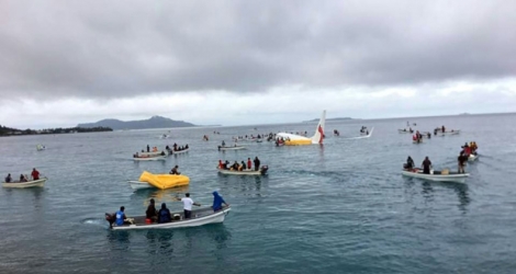 Des bateaux de sauveteurs s'approchent d'un avion de la compagnie Air Niugini qui a plongé dans un lagon après avoir raté son atterrissage, le 28 septembre 2018 sur l'île de Weno, en Micronésie.