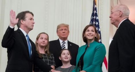 Le juge Brett Kavanaugh (g) prête serment en présence du juge Anthony Kennedy (d), de sa femme et de ses deux filles et du président Donald Trump, le 8 octobre 2018 à la Maison Blanche, à Washington.
