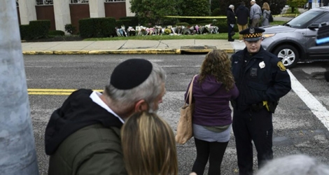 Des gens se réconfortent devant la synagogue de Pittsburgh où un tireur a tué onze fidèles samedi. 