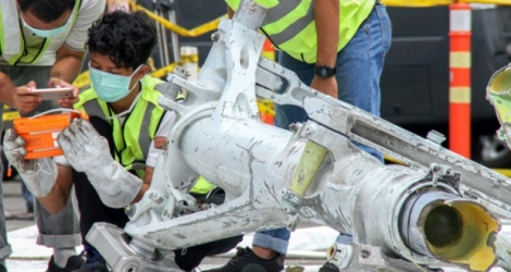 Au nord de Jakarta, le 5 novembre 2018, des enquêteurs de Lion Air examinent une partie du train d'atterrissage du Boeing qui s'est abîmé le 29 octobre au large de l'Indonésie.