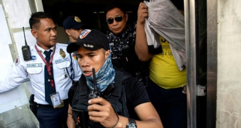 Un policier (t-shirt jaune), impliqué dans le meurtre d'un adolescent en 2017, est escorté hors du tribunal régional de Caloocan, le 29 novembre 2018 à Manille, aux Philippines.