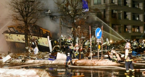 Des pompiers viennent en aide à des blessés après l'explosion d'un restaurant à Sapporo, sur l'île septentrionale japonaise de Hokkaido, le 16 décembre 2018.