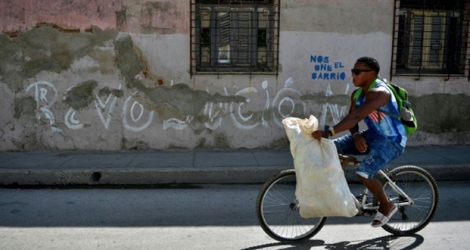 Un homme passe en vélo devant un graffiti 