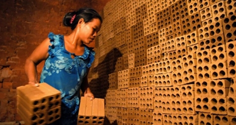 Une cambodgienne travaille dans une fabrique de briques dans la banlieue de Phnom Penh, le 11 décembre 2018