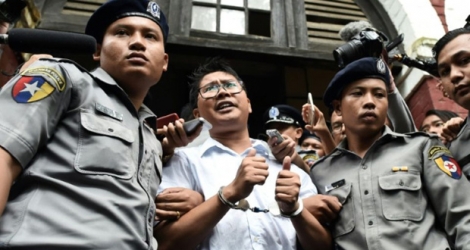 Le journaliste birman Wa Lone (c), escorté par des policiers, après sa condamnation à sept ans de prison, le 3 septembre 2018 à Rangoun.