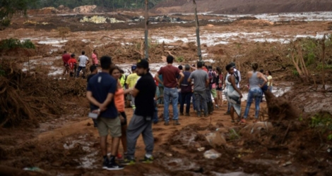 Des habitants contemplent l'étendue du désastre au lendemain de la rupture d'un barrage minier ayant fait au moins 37 morts et 300 disparus dans l'est du Brésil, le 26 janvier 2019. 