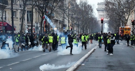 Un manifestant renvoit une grenade lacrymogène lors de la 13e manifestation des 