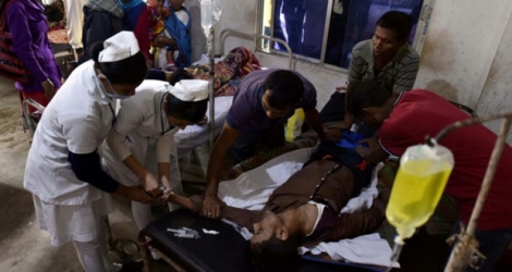 Un patient qui a absorbé de l'alcool frelaté est soigné dans un hôpital, dans le district de Golaghat dans le nord-est de l'Inde le 23 février 2019.