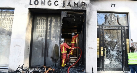 Les pompiers interviennent sur un feu à la boutique Longchamp, pendant la manifestation des 
