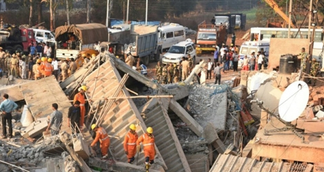 Des secouristes, le 20 mars 2019, dans les décombres d'un bâtiment qui s'est effondré la veille, dans le district de Dharwad, en Inde.