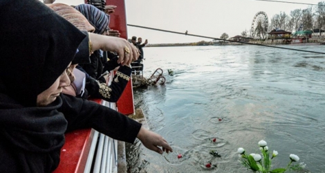 Des Irakiennes lancent des fleurs dans le fleuve Tigre à la mémoire des victimes d'un naufrage, le 22 mars 2019 à Mossoul.