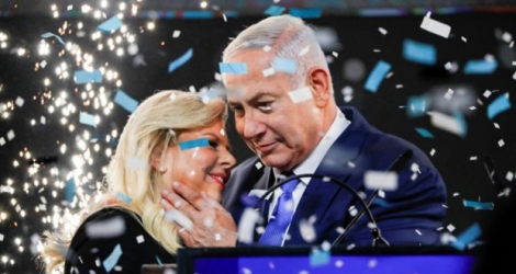 Le Premier ministre israélien embrasse son épouse Sara sous une pluie de confettis et de feux d'artifice au quartier général du Likoud à Tel Aviv le 10 avril 2019.