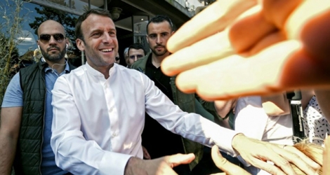 Le président Emmanuel Macron (C) salué par la foule dans les rues du Touquet (Pas-de-Calais), le 21 avril 2019.