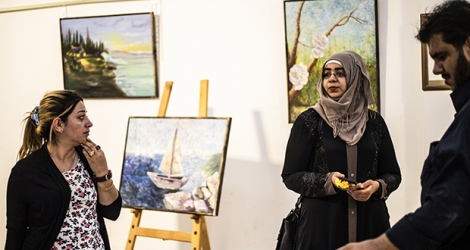 Des habitants de Raqa admirent des œuvres d’art le 1er mai 2019 durant une exposition dans un centre culturel, le premier à ouvrir depuis la fin du règne du groupe Etat islamique à Raqa.