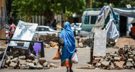Une Soudanaise marche en direction d'une barricade erigée à proximité du sit-in des contestataires dans le centre de Khartoum, le 14 mai 2019.