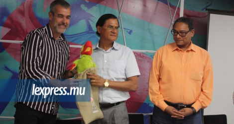 Le président du CIJ, Antonio Gopal, qui reçoit ici une reproduction de la mascotte des JIOI, Krouink, des mains du CEO du COJI sous le regard du ministre Toussaint, tient absolument à ce que le drapeau des Jeux soit remis à l’île hôte de la 11e édition le 28 juillet prochain.