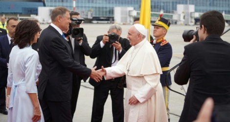 Le pape François est accueilli par le président roumain Klaus Iohannis à son arrivée à l'aéroport Henri Coanda de Bucarest le 31 mai 2019.
