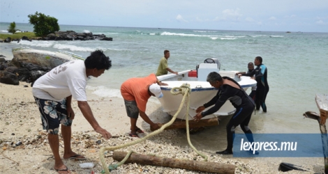 Des pêcheurs retirent une pirogue de la mer en raison d’une alerte cyclonique.