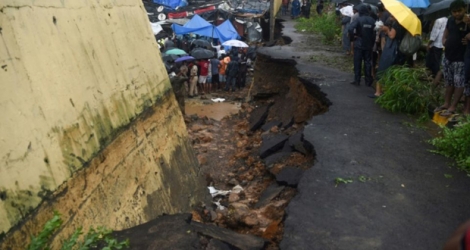 Des équipes de secours et des habitants sur les lieux de l'effondrement d'un mur provoqué par des pluies torrentielles, le 2 juillet 2019 à Bombay, en Inde.