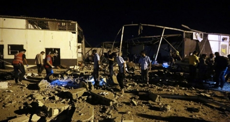 Des secouristes retirent des corps des décombres d'un hangar visé par un raid aérien dans un centre de détention de migrants à Tajoura près de la capitale libyenne Tripoli, le 3 juillet 2019.