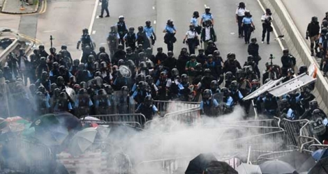 Photo du 12 juin 2019 montrant un affrontement entre policiers et manifestants devant le siège du gouvernement à Hong Kong.
